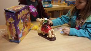 Bild: Kind mit Spielschachtel und Spielmaterial