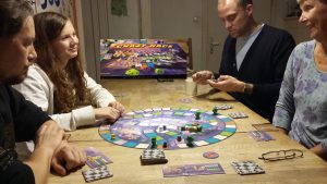Bild: Spielergruppe um das Spielmaterial am Tisch sitzend