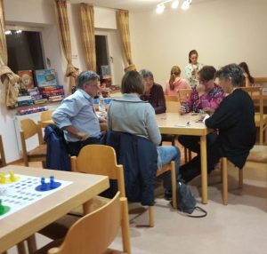 Bild: Erwachsene am Tisch sitzend beim Spiel