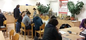Bild: im Spielecafé sitzen viele Spieler an Tischen zum gemeinsamen Spiel