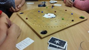 Bild: hölzernes Spielbrett mit Spielmaterial