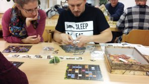 Bild: Spielmaterial auf tisch liegend mit Spielern