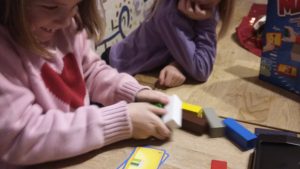 Bild: Mädchen, das einen Holzklotz in den Händen hält