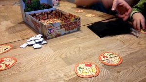 Bild: geöffnete Spielschachtel und Spielmaterial auf Tisch