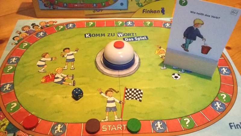 Bild: Spielfeld mit Buzzer, Spielsteinen und Spielkärtchen