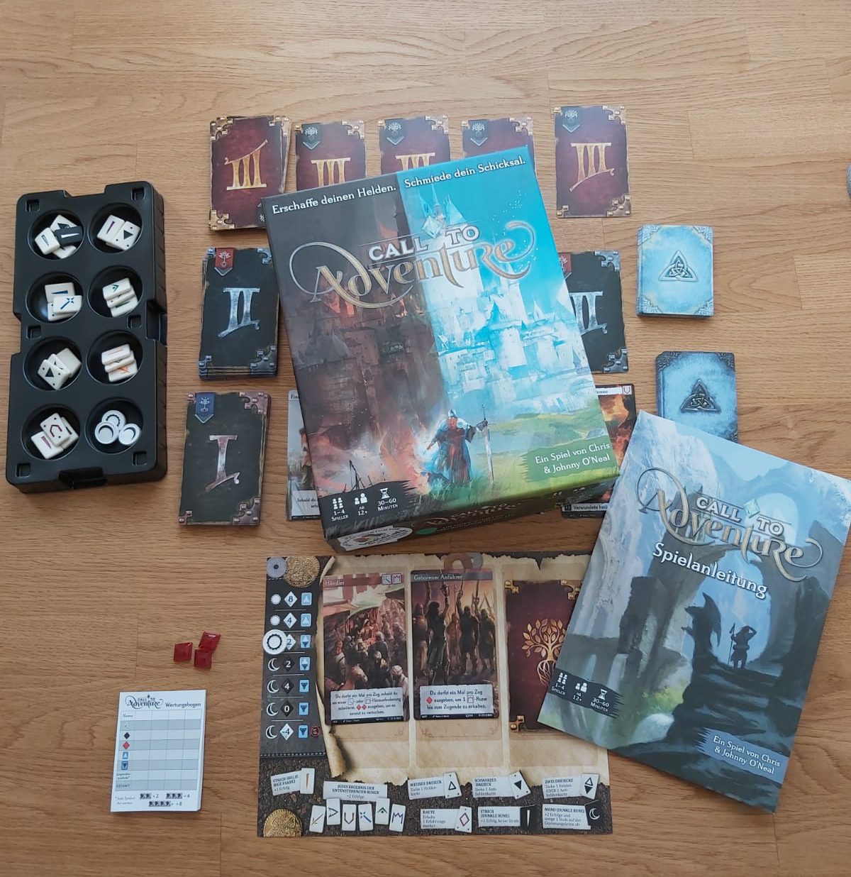 Zu sehen ist das gesamte Spielmaterial von Call to Adventure inkl. Verpackung