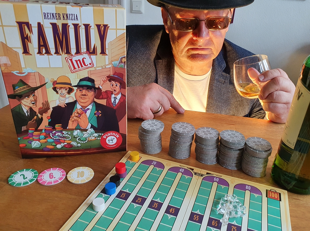 Spielkarton und Inhalt, Rezensent mit Hut und Sonnenbrille