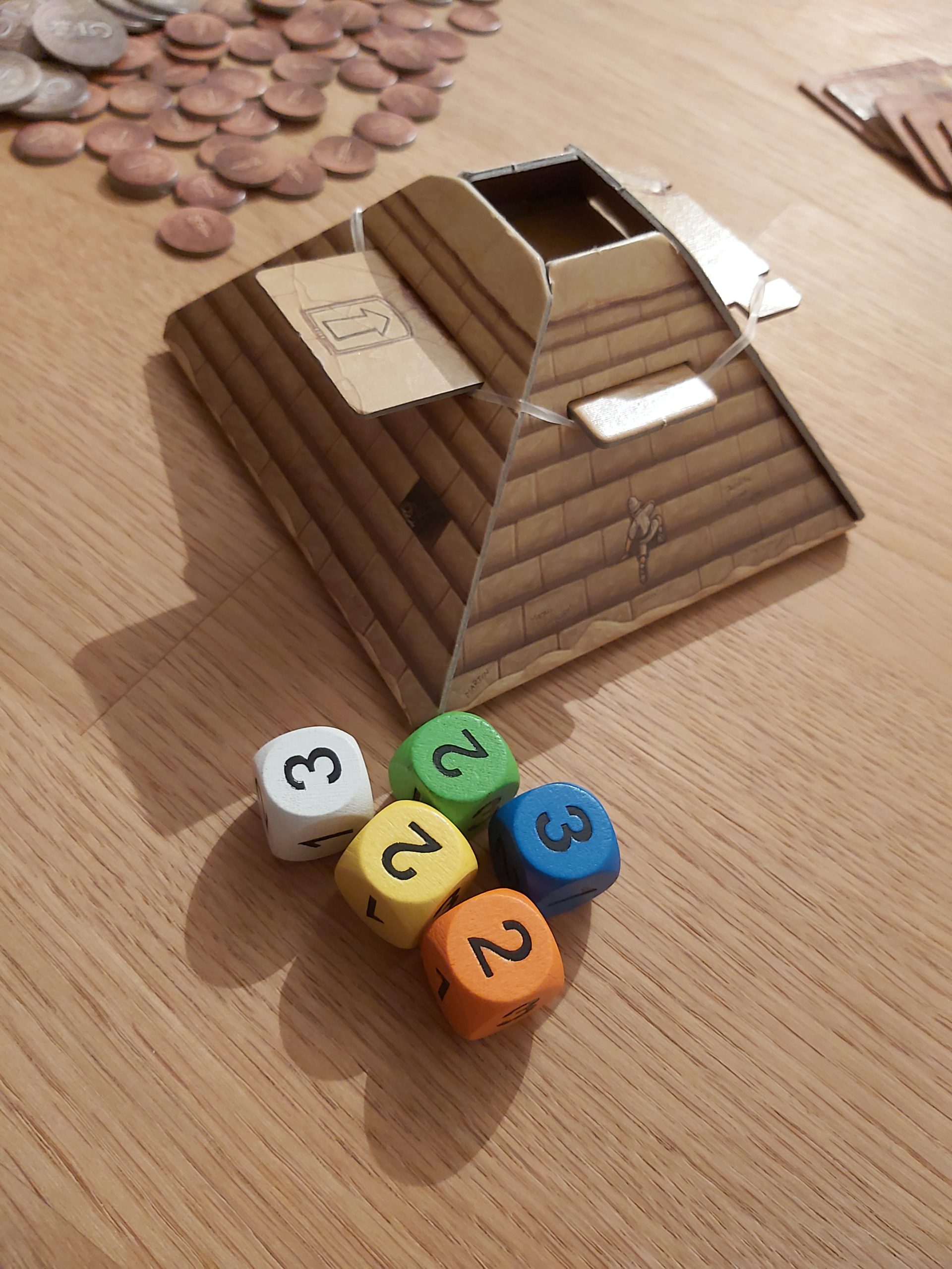 Zu sehen ist die Pyramide von Camel Up samt Würfel.