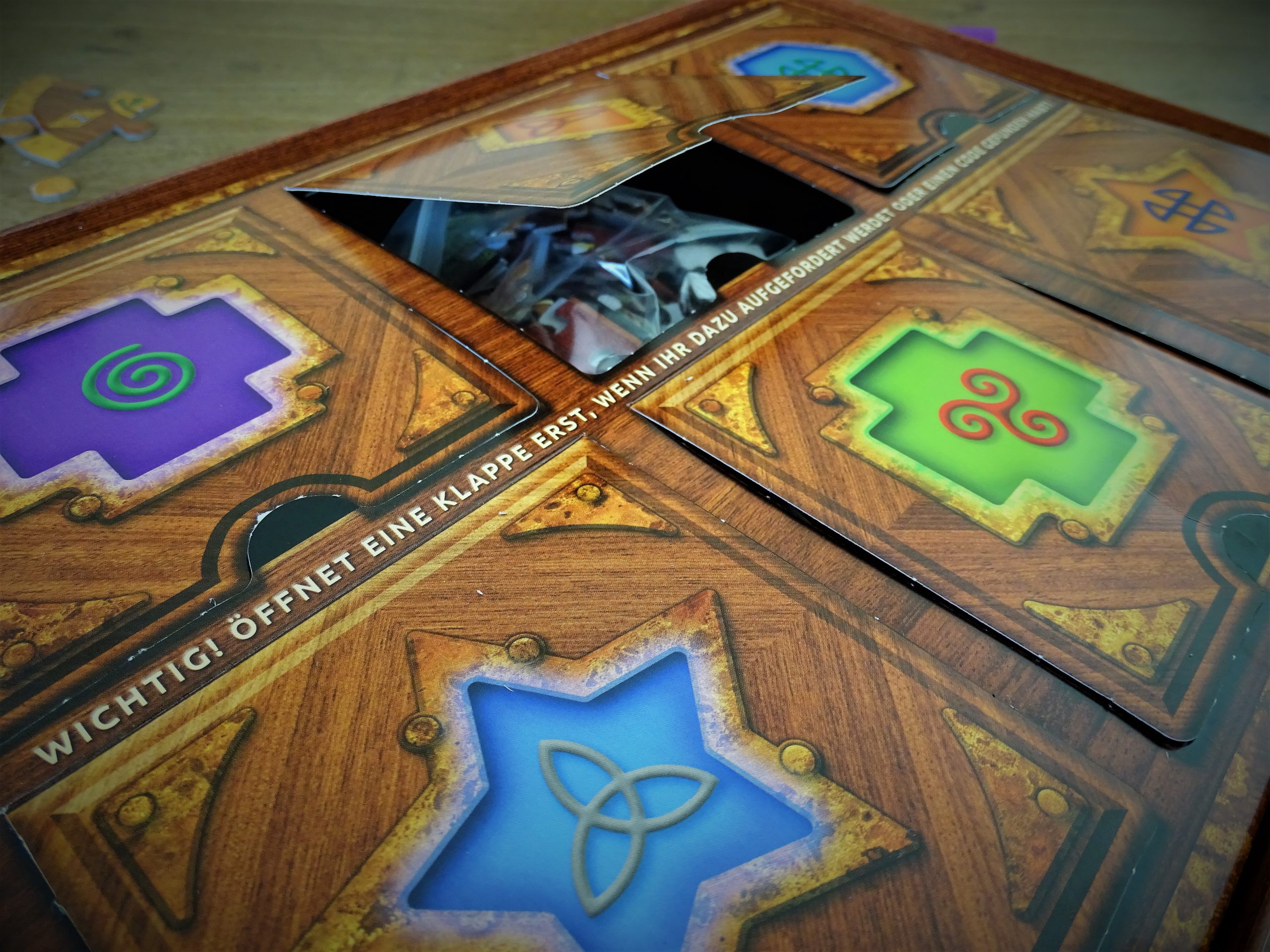 Klappen mit bunten Symbolen beherbergen das Spielmaterial.