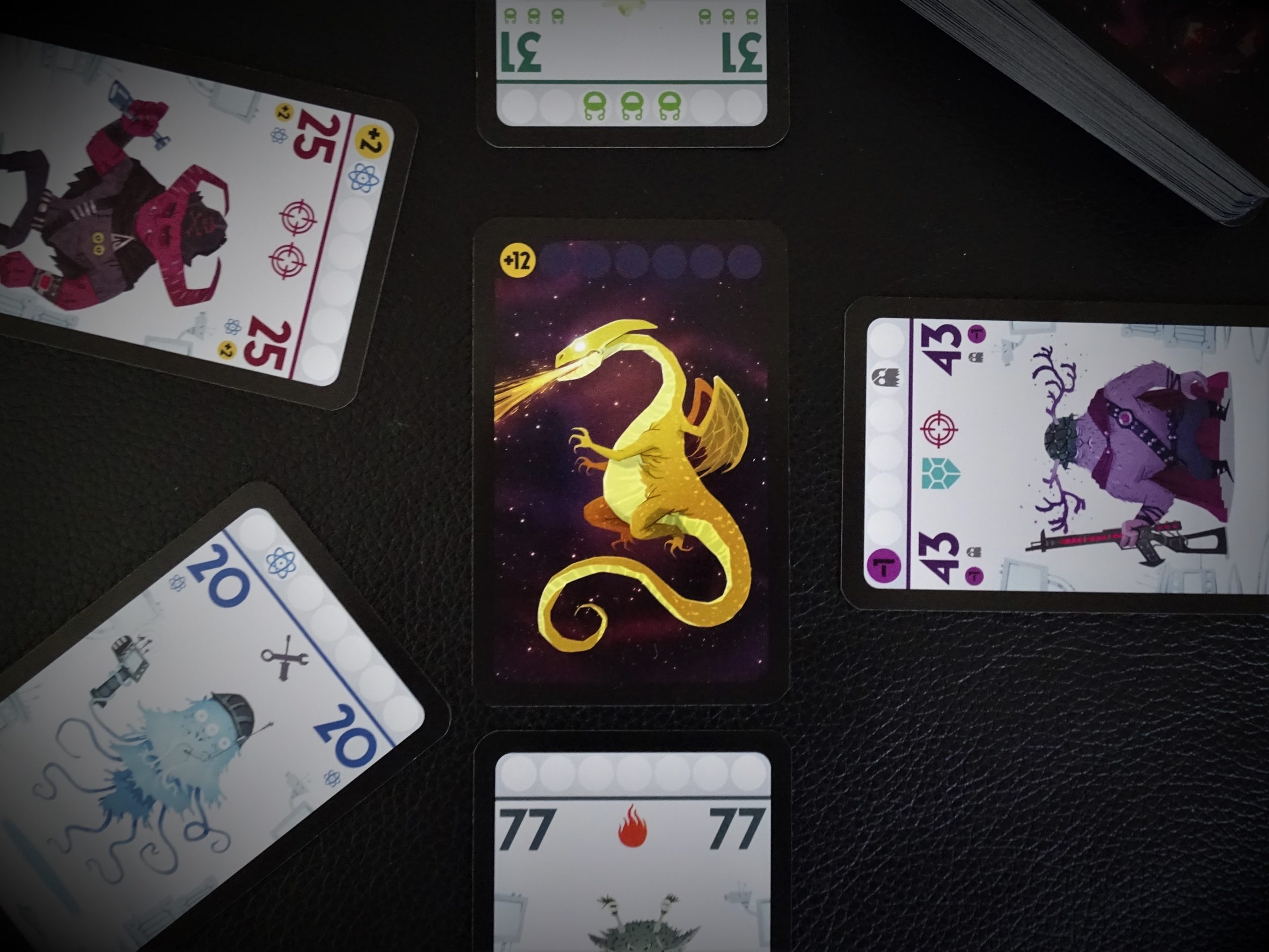 Fünf Spielende kämpfen um den Drachen. Die Karte 77 hat den größten Zahlenwert. 