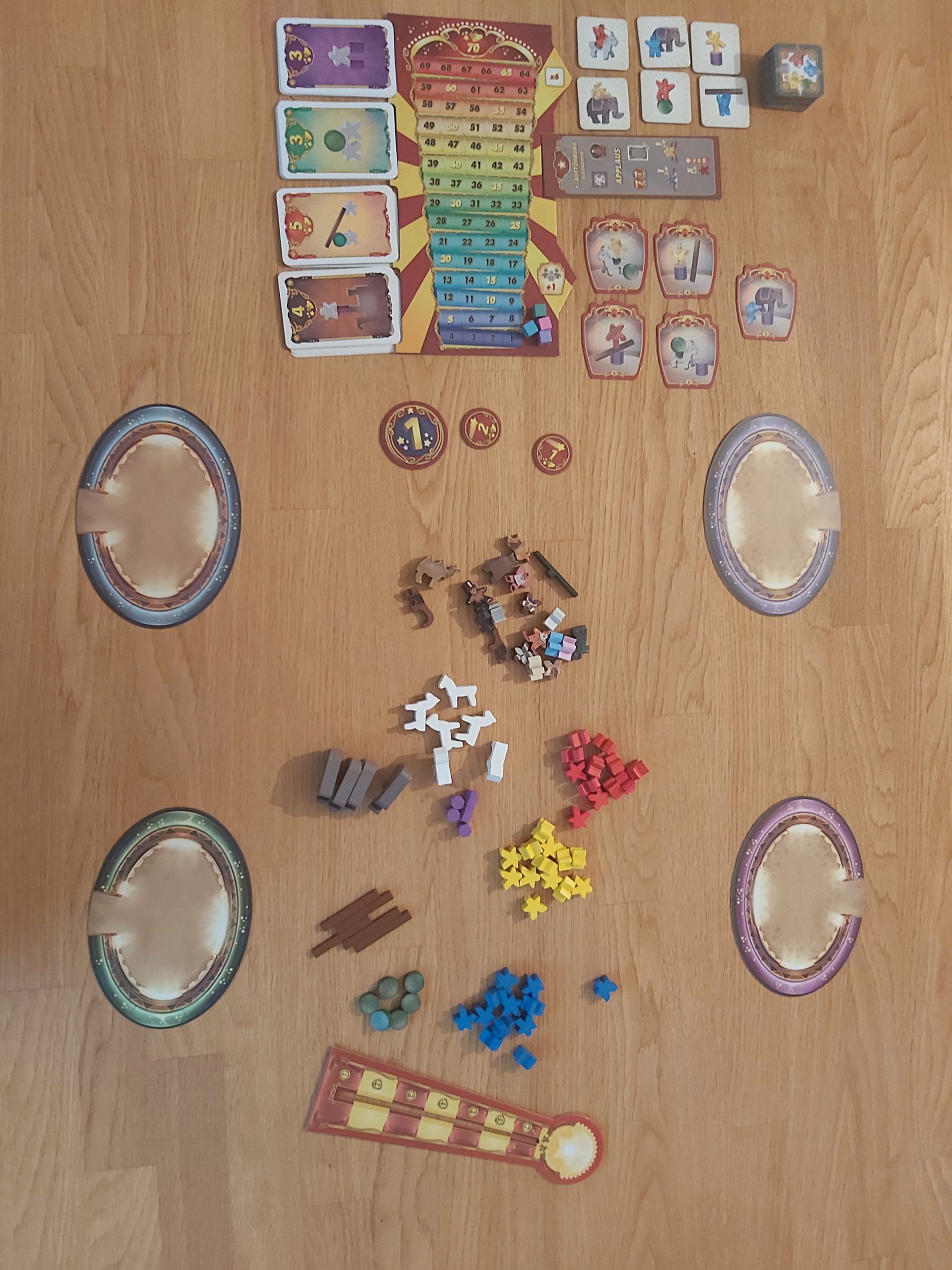 Zu sehen ist der Spielaufbau von Meeple Circus für 4 Spielende
