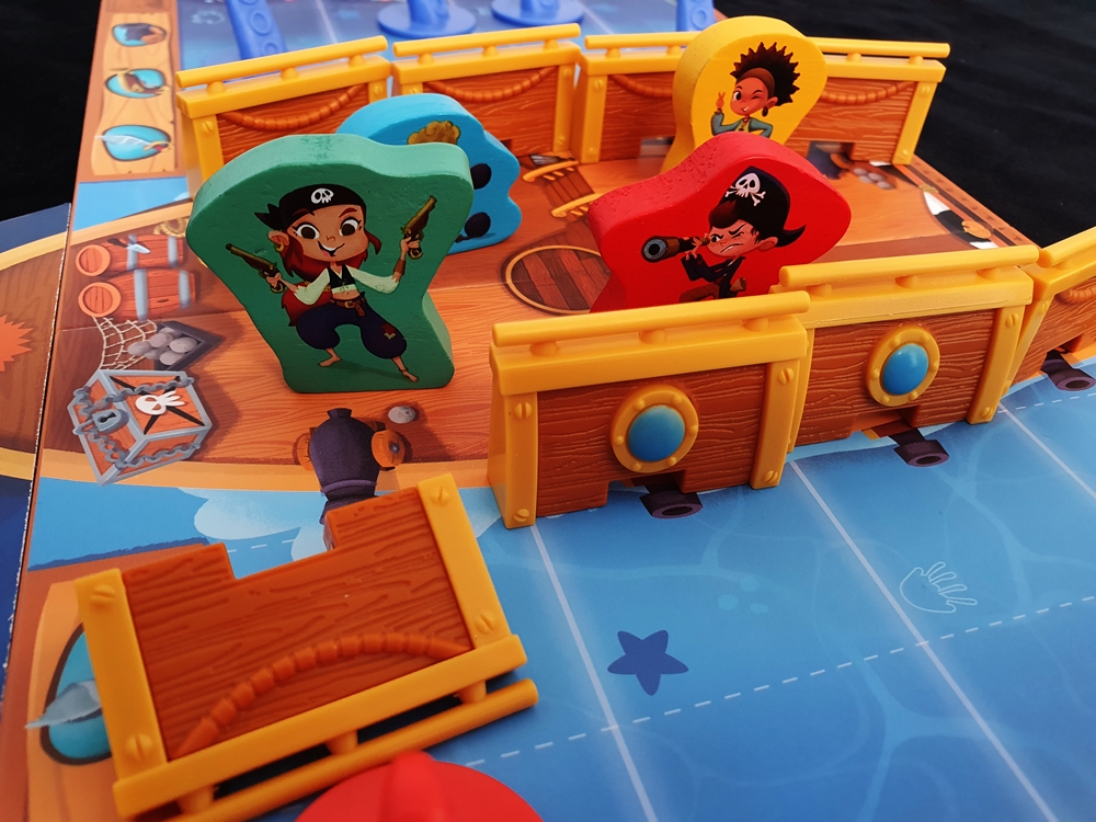 Das Schiff, darauf Spielfiguren, eine Reling gekippt