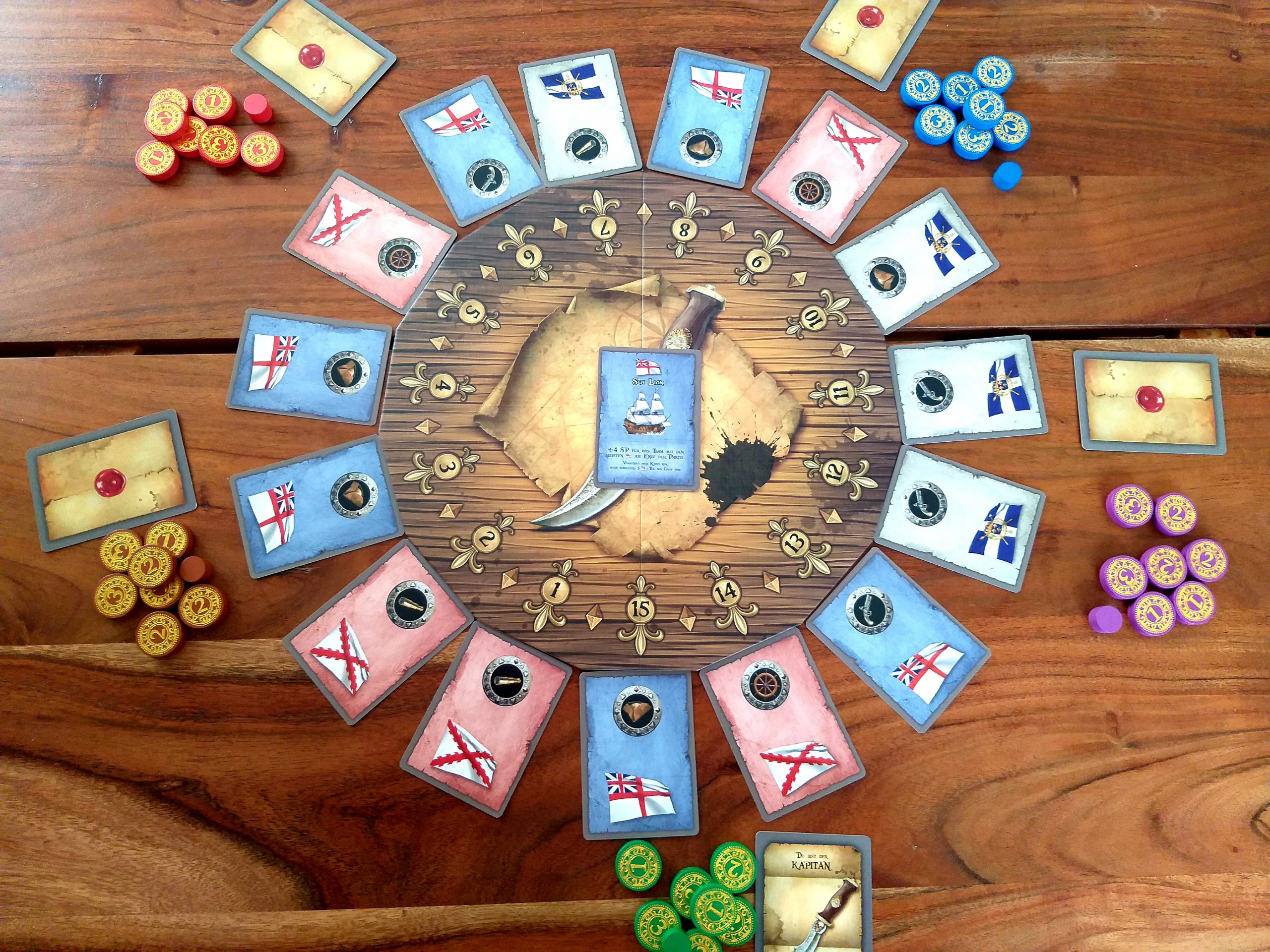 Aufbau für 5 Spielende. Nur die Rolle des Kapitän (grün) ist zu Spielbeginn bekannt.