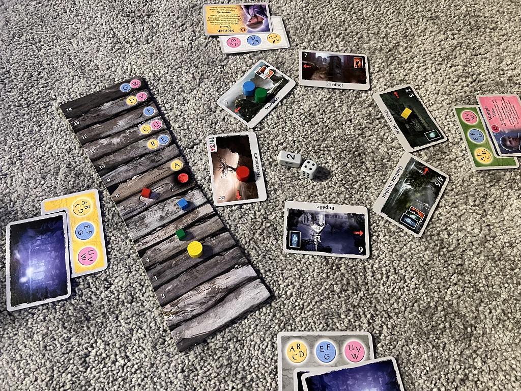 Spielaufbau mit den Orten und der Energieleiste, Markern und Würfeln