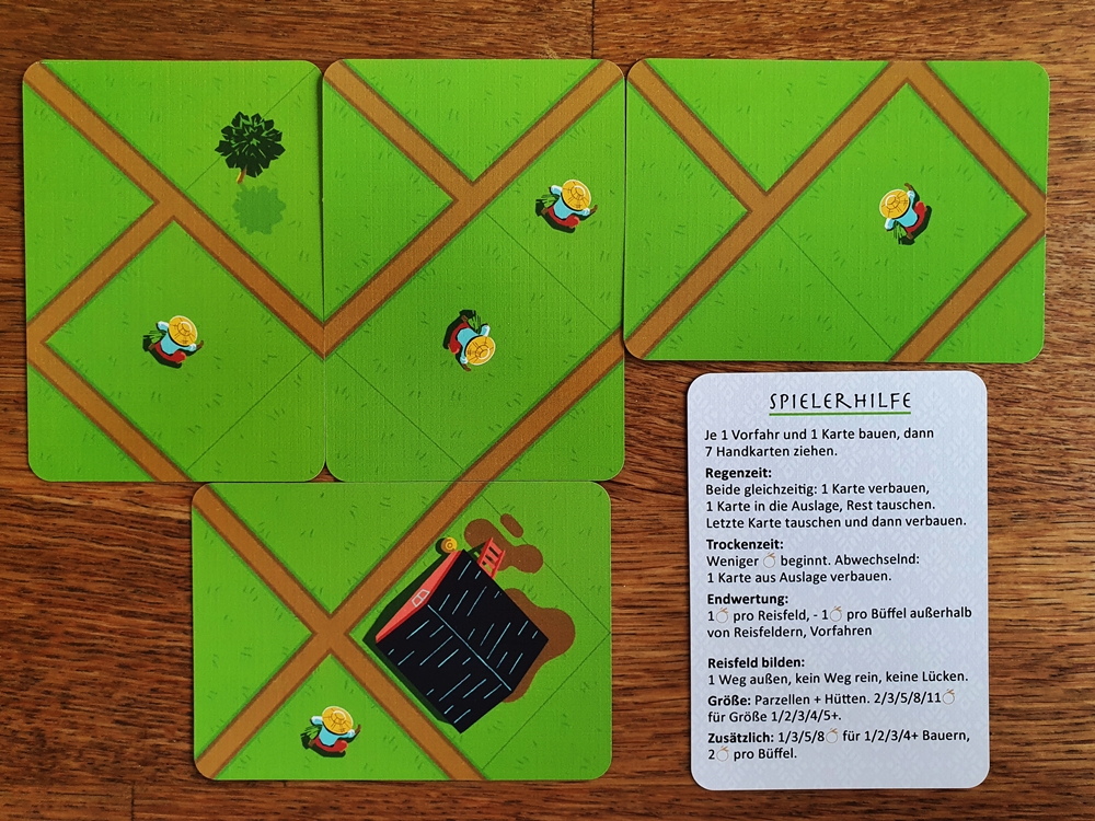 Auslage von vier Karten, dazu die Karte "Spielhilfe"