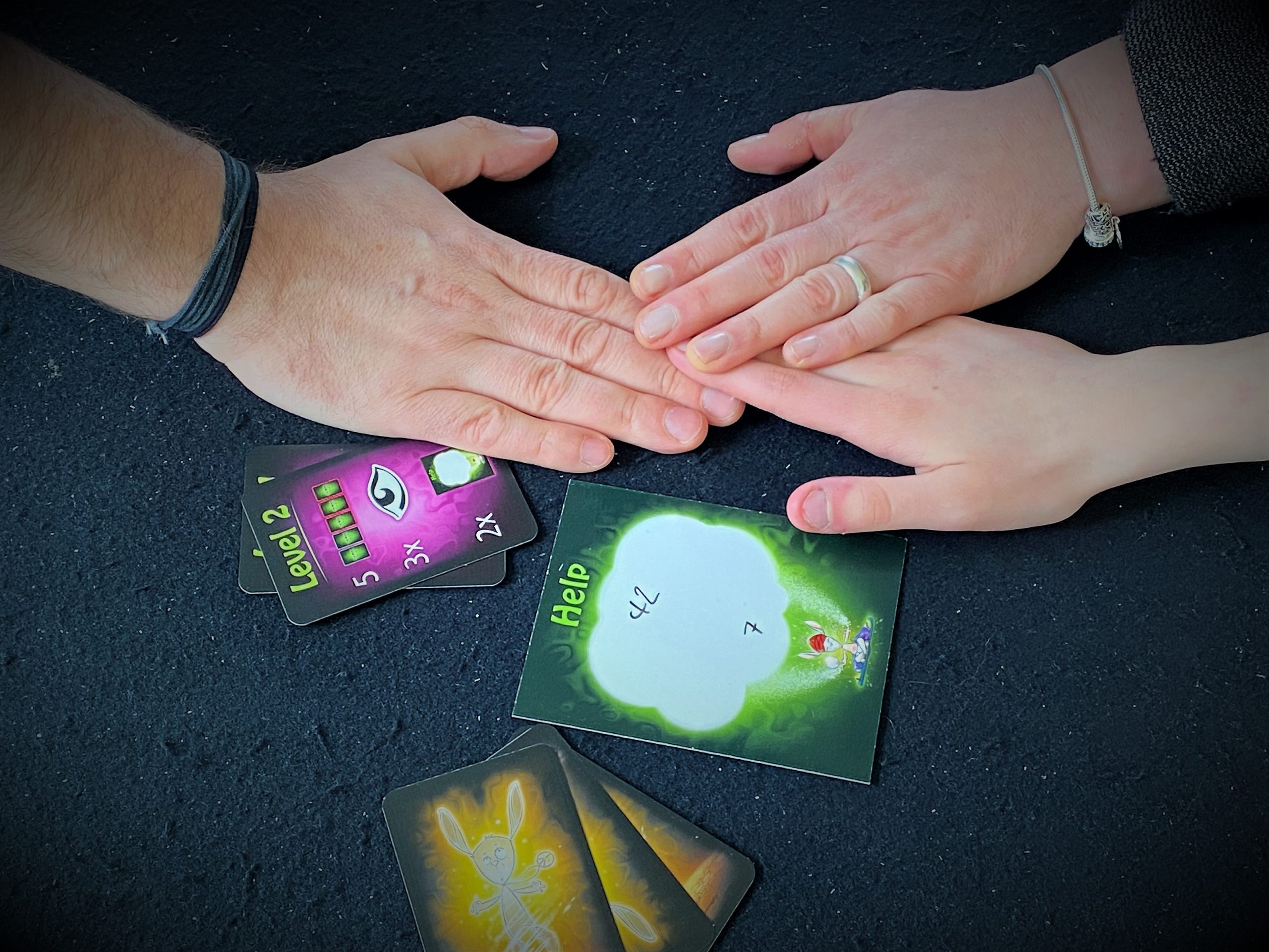 Drei Personen mit der Hand in der Tischmitte. Das Ritual beginnt.