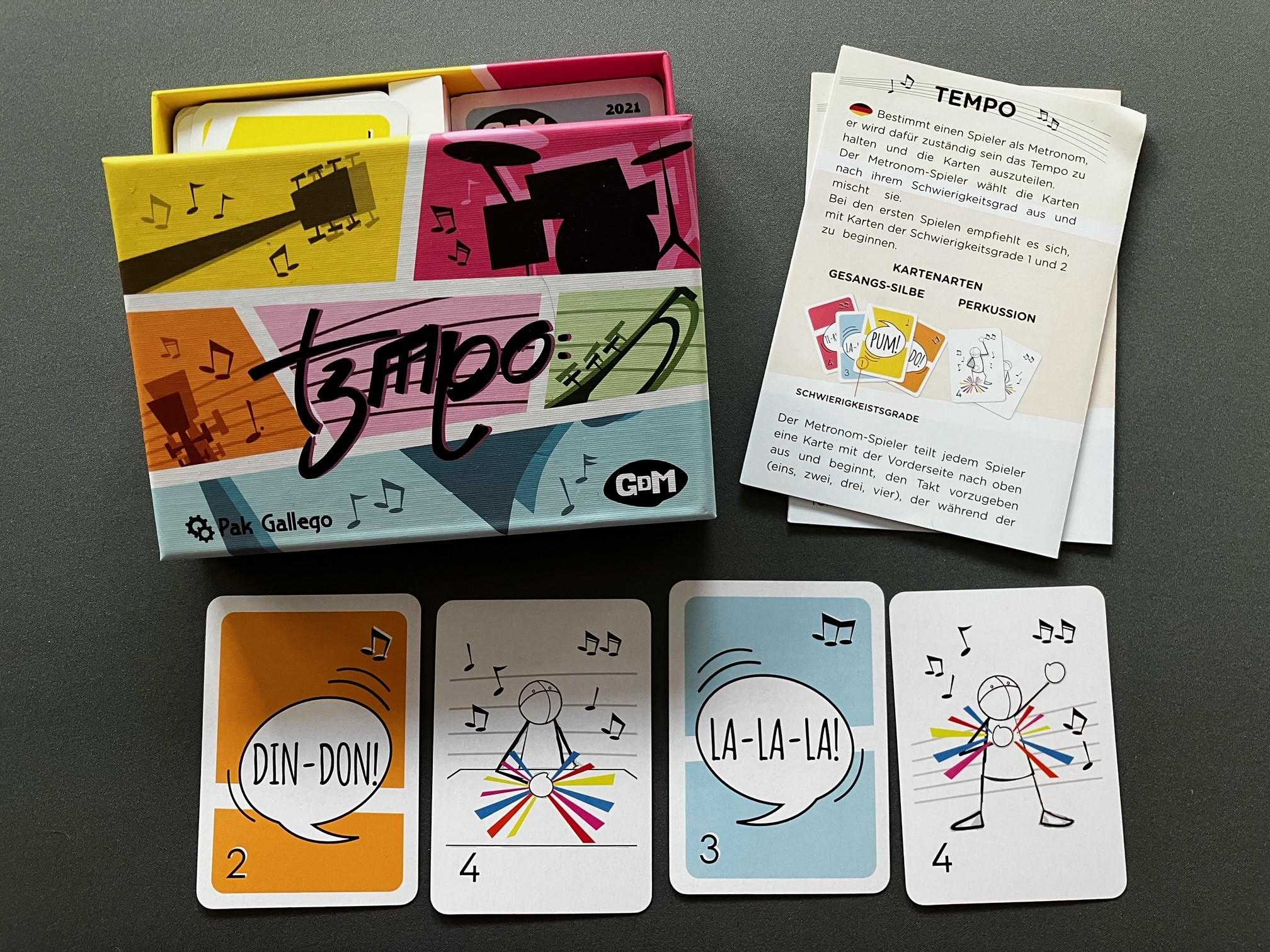 Eine 4er Folge der Karten liegt aus - darüber die Spielschachtel sowie die Spielanleitung in 2 Sprachen.