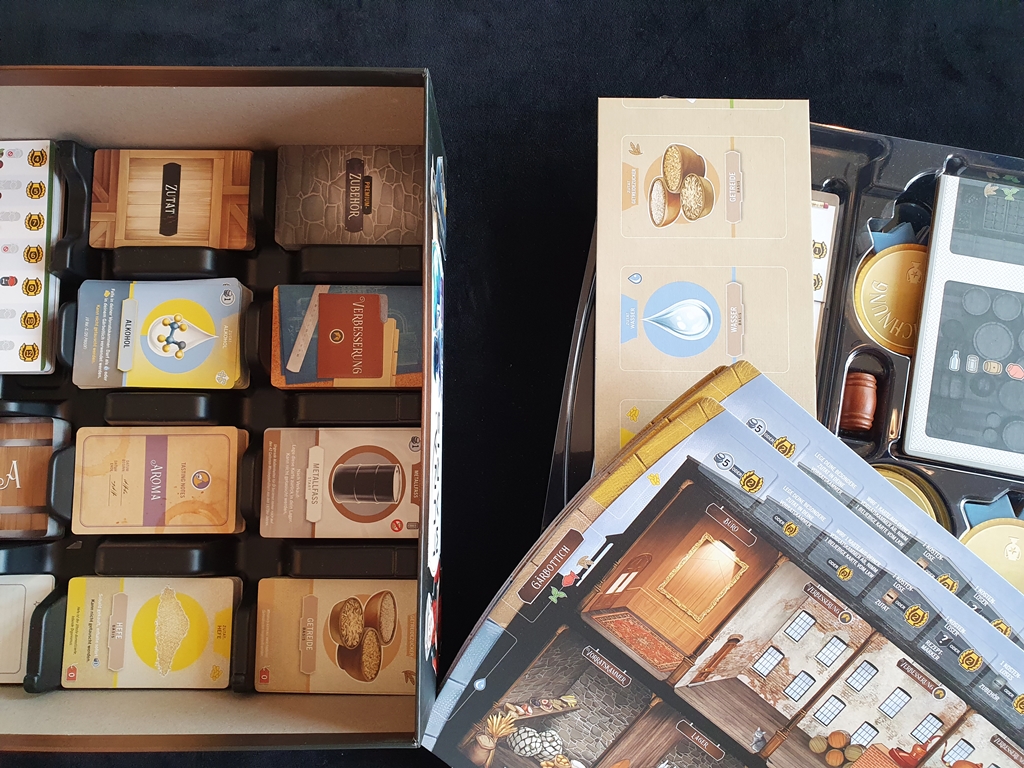 Spielkarton beim Einsortieren des Materials