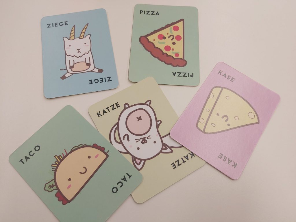 Zu sehen sind die Standardkarten des Spiels "Taco Katze Ziege Käse Pizza"