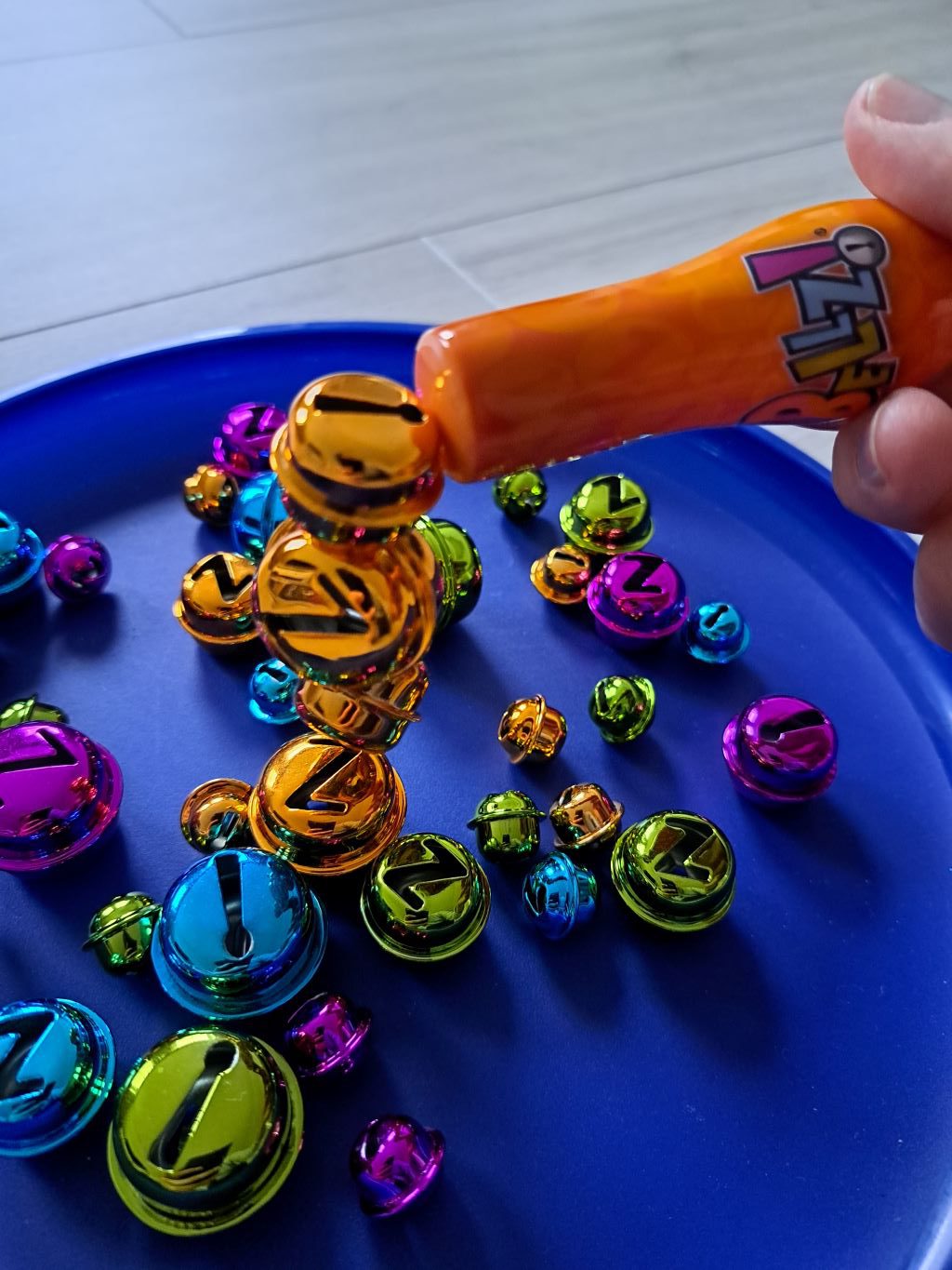 Der Magnet hebt vier gelbe Glöckchen