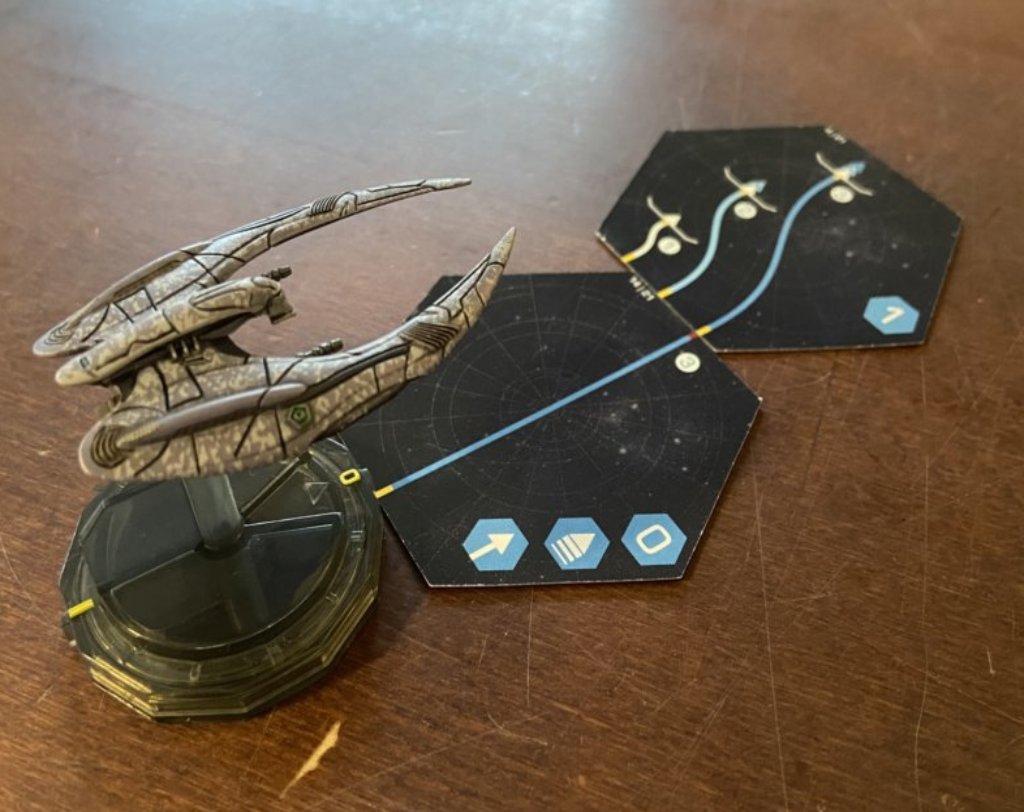 Ein Raumschiff mit zwei davor ausliegenden Karten, die die Bewegungsrichtung vorgeben.