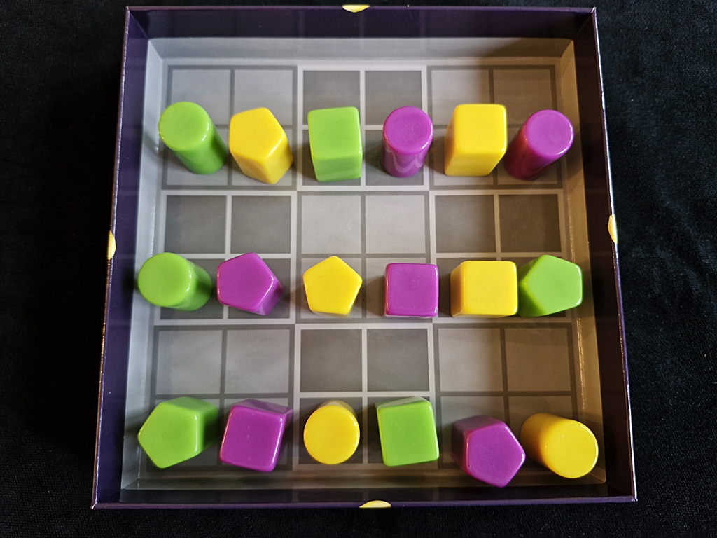 Der Startaufbau. Spielfeld ist das Innere des Spielkartons, aufgeteilt in Quadrate.