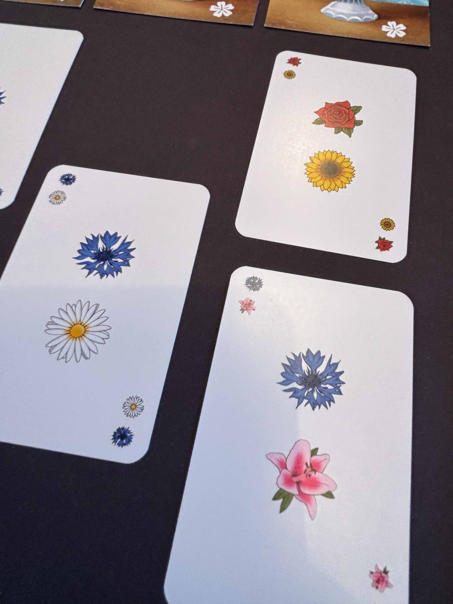 Karten mit Blumen im Raster ausliegend.