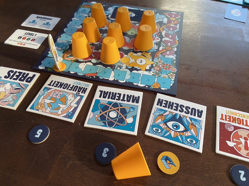 Von den Bechern auf dem Spielplan wurde einer bereits aufgedeckt.