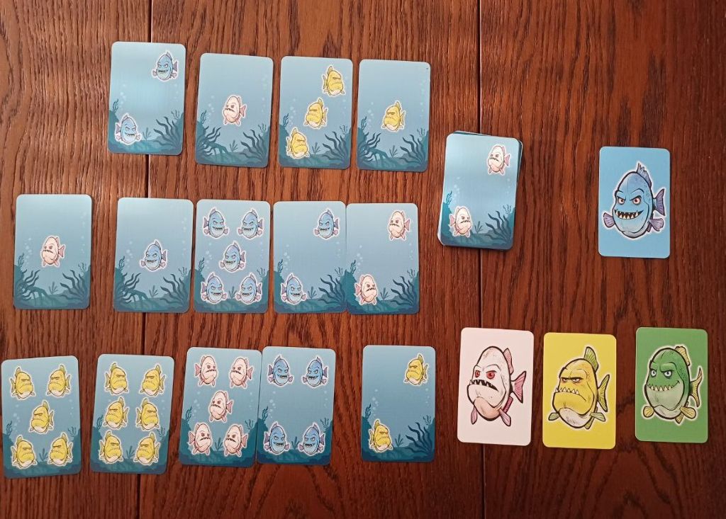 Kartenauslage zum Ende der kooperativen Variante, blaue Fische werden verteidigt, aber gelb greift an