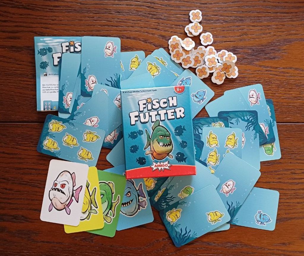 Material des Spiels Fischfutter: Karten, Aua-Marker, Spielanleitung