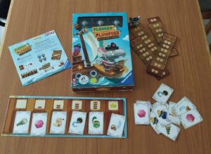 Auf dem Foto ist die Schachtel vom Spiel Planken-Plumpser zu sehen mit dem dazugehörigem Material.