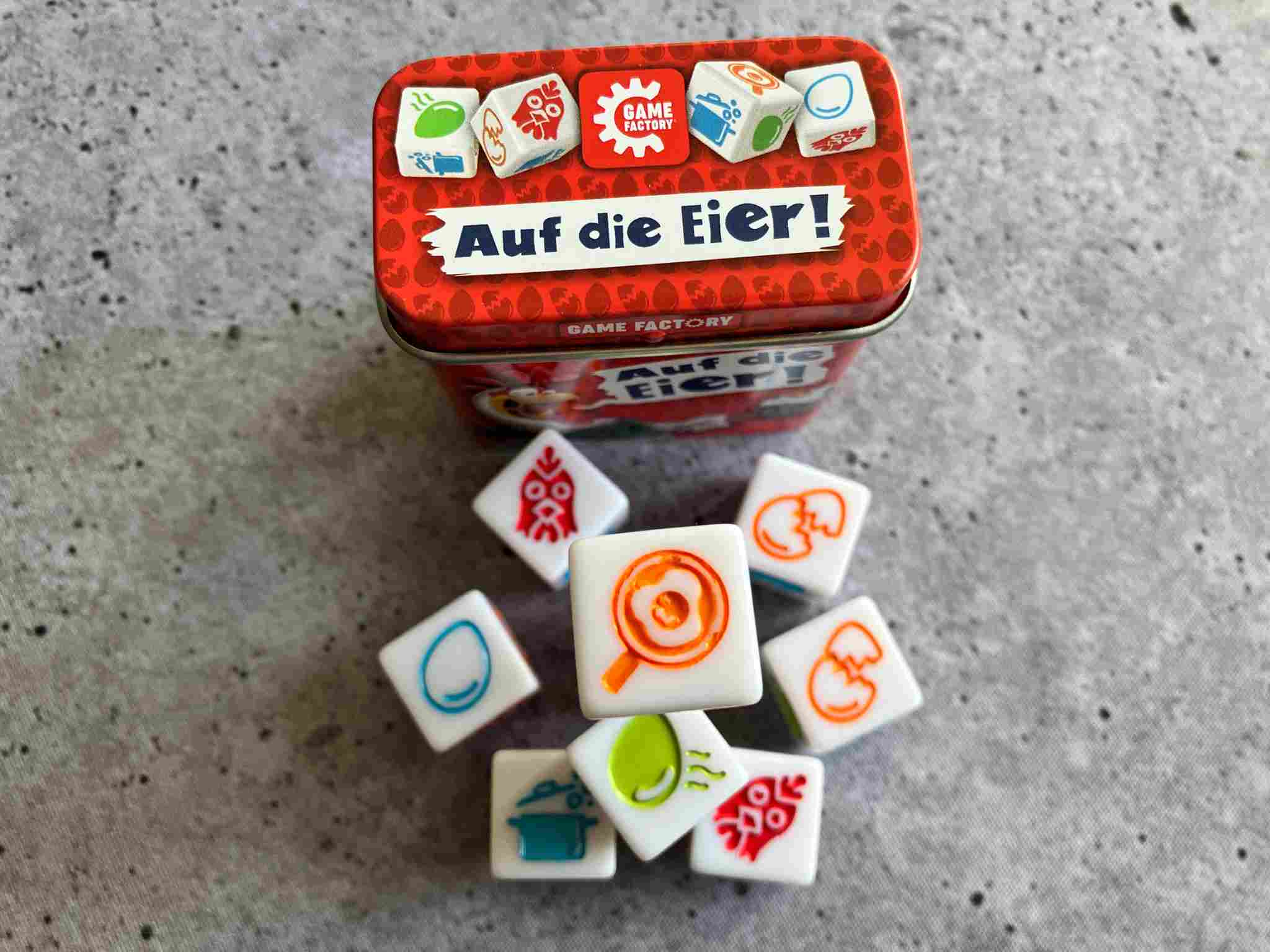 Auf die Eier - alle 9 Würfel des Spiels liegen vor der Schachtel