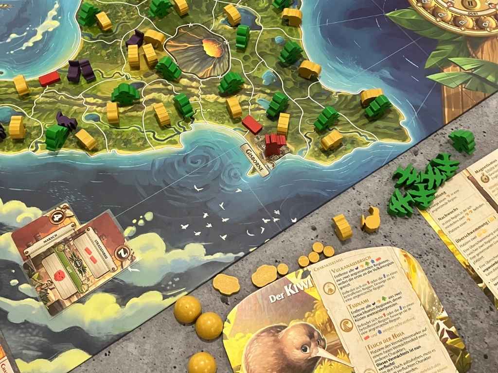 Ein Teil des Spielplanes im Bild, zu erkennen sind 2 der Aktionskarten des Engländers sowie viele bunte Spielsteine und das Tableau der Kiwi.