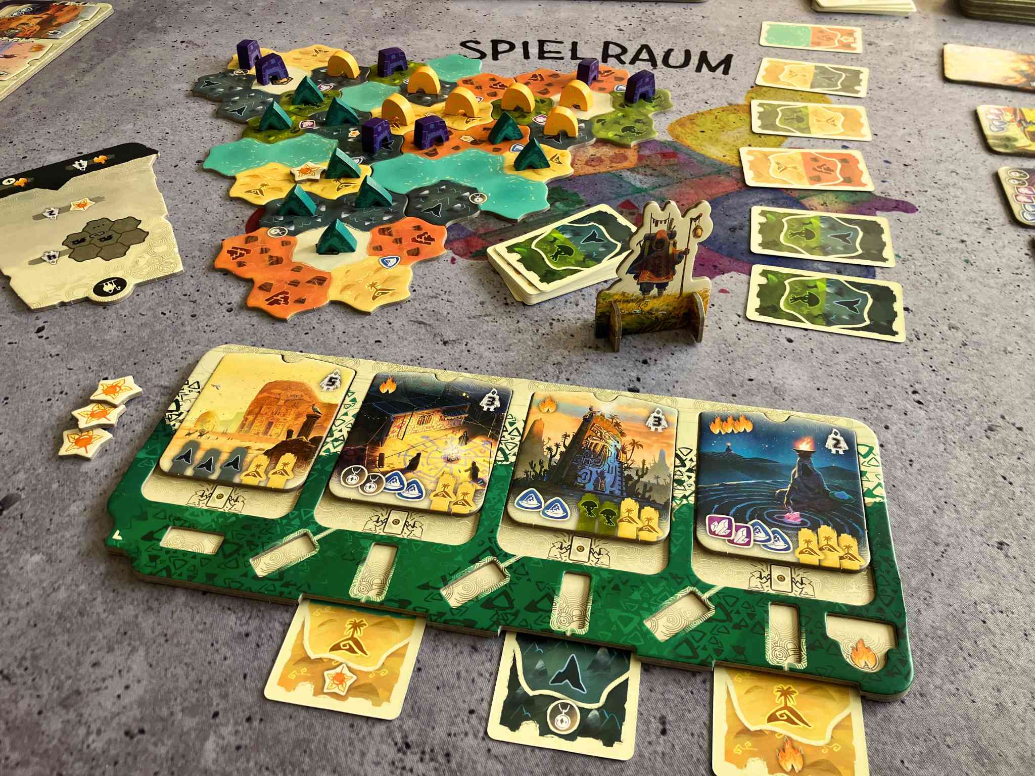 Blick auf den Tisch, es liegen Spielmaterialien mit kleinen Holzspielfiguren darauf.