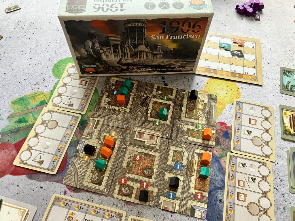 1906 San Franzisco: Spielszene. Der Spielplan bestehend aus vielen Karten sowie die Spielschachtel drauf gestellt.