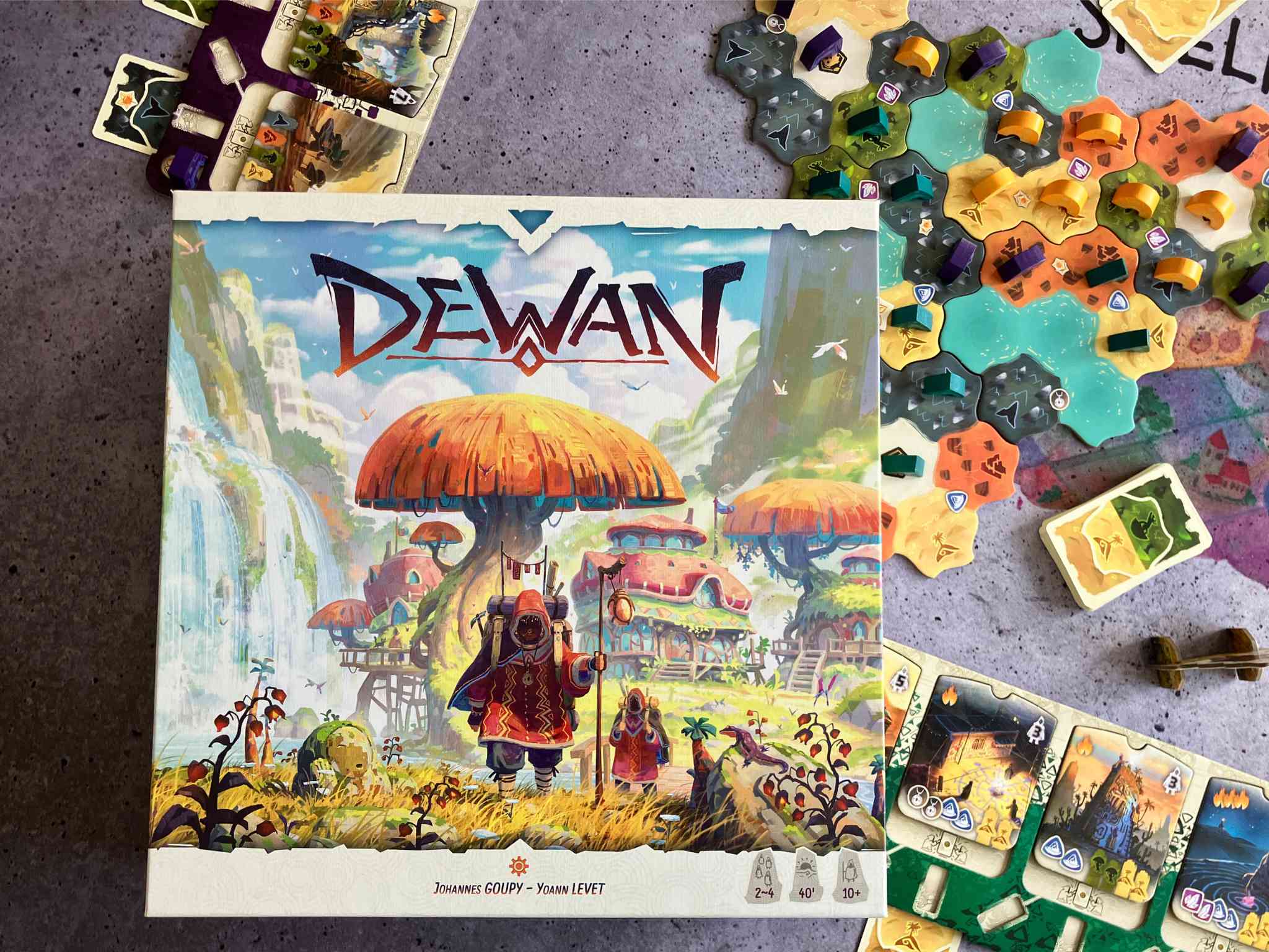 Die Spieleschachtel liegt auf einem Teil des bunten Spielmaterials.