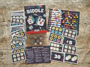 In der Schachtel sind 6 Würfel, Spielsteine und Aufgabenkarten.